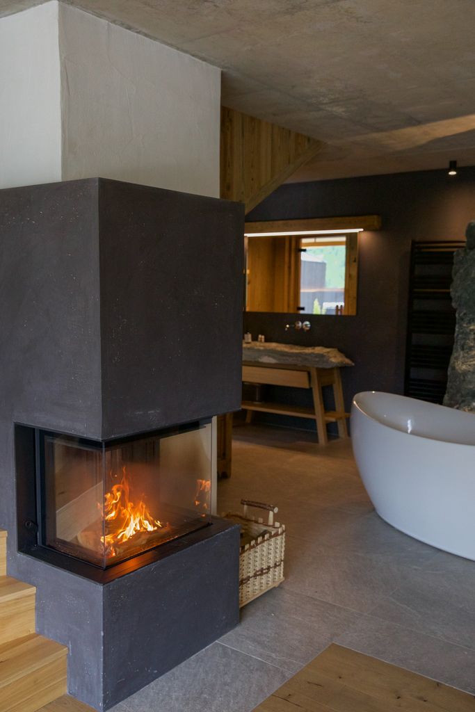 Contemporary bathroom with modern fireplace, minimal design, and warm lighting.